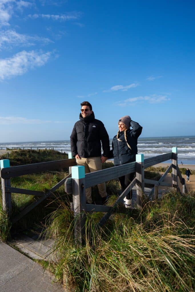 Stelletje klimt trap op bij Strandopgang Zandvoort in winter